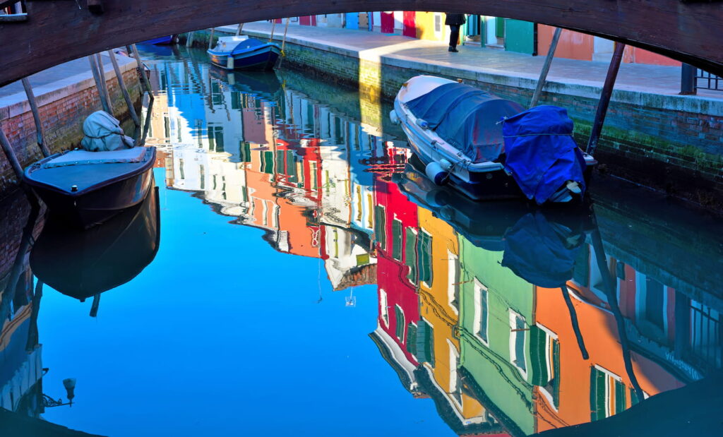 Case colorate di Burano si riflettono sull'acqua del canale